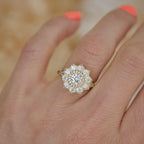 On-finger view of a yellow gold 1.5 CT round lab created diamond engagement ring showing the starburst halo head proportion.