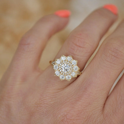 On-finger view of a yellow gold 1.5 CT round lab created diamond engagement ring showing the starburst halo head proportion.
