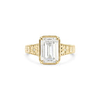 Studio product shot of a 3 CT emerald cut lab grown diamond engagement ring in solid 14K yellow gold with an engraved band.