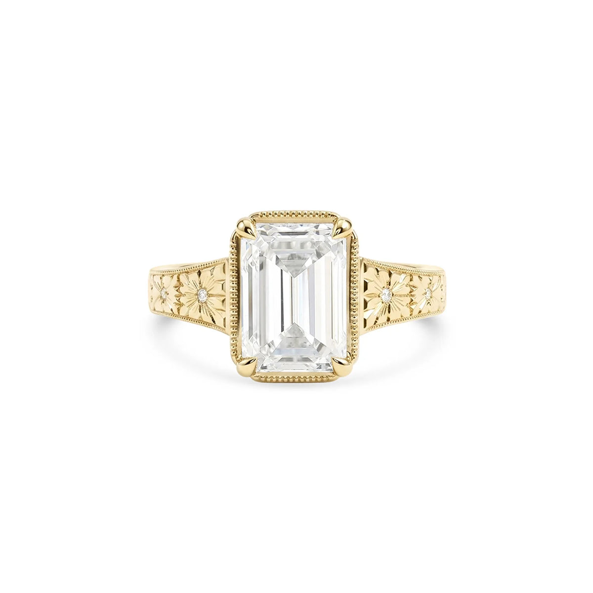 Studio product shot of a 3 CT emerald cut lab grown diamond engagement ring in solid 14K yellow gold with an engraved band.