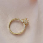 Side profile view of a yellow gold 2 CT round lab grown diamond engagement ring showing the filigree basket and engraved shank.