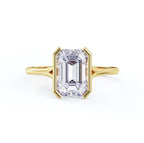 Top view of a 3 carat emerald cut lab grown diamond in a polished yellow gold half-bezel solitaire setting.
