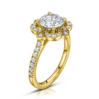 Three-quarter angled view of a 3 carat round lab grown diamond engagement ring with a vintage floral milgrain halo in yellow gold.