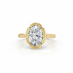 Top-down view of a 3 CT oval lab grown diamond solitaire ring encased in a contoured scalloped bezel frame with a smooth yellow gold band.