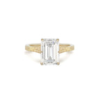 Front view of a 3 CT emerald cut lab grown diamond solitaire ring in 14K yellow gold with a hand-engraved botanical band.