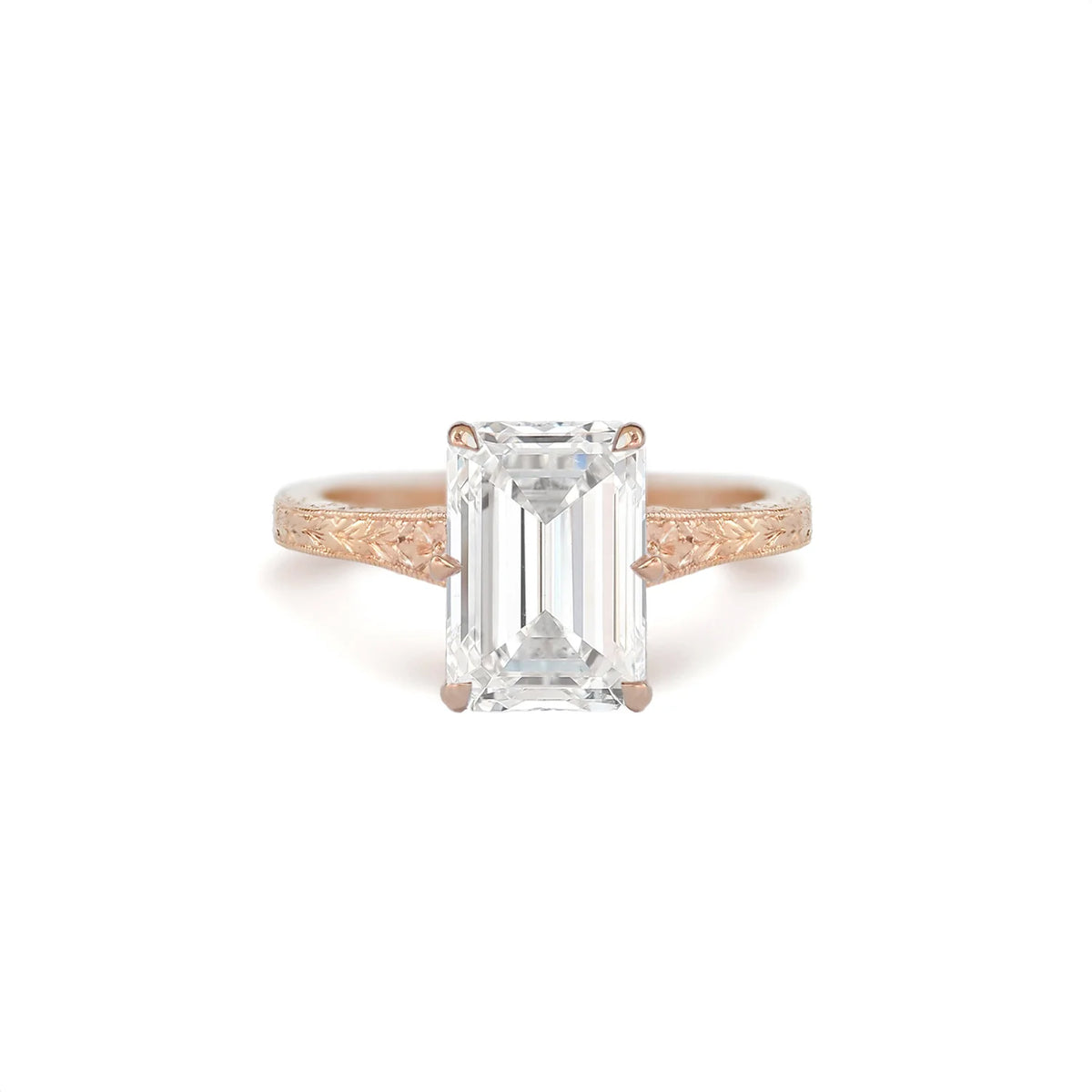 Front view of a 3 CT emerald cut lab created diamond engagement ring in rose gold featuring intricate vintage etched side shoulders.