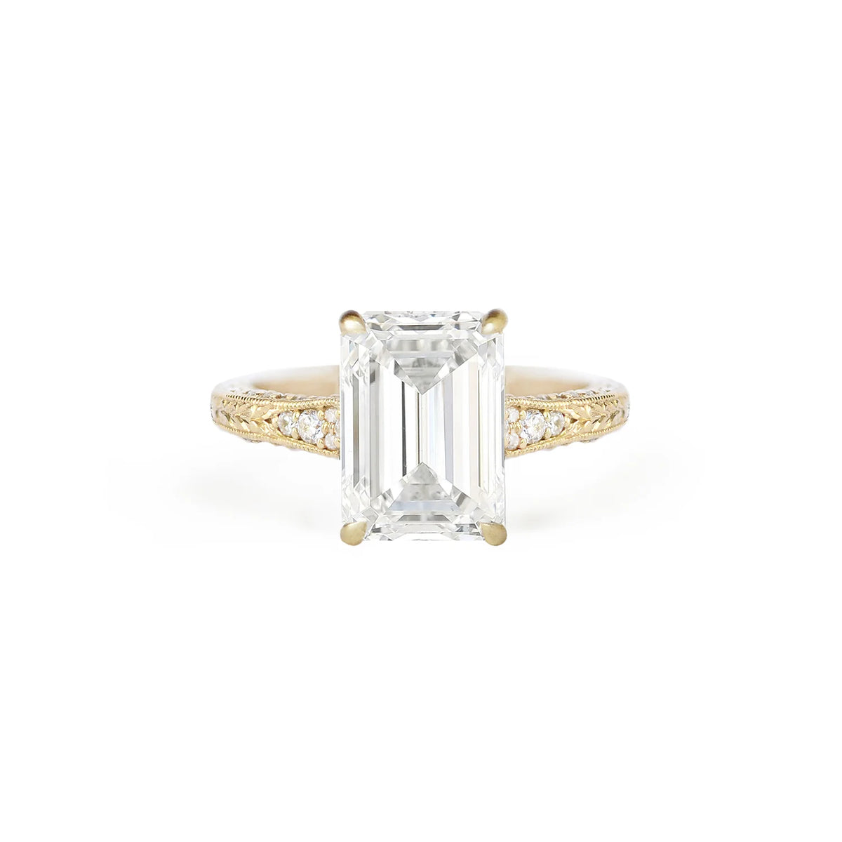 Front studio view of a 3 CT emerald cut lab diamond ring in yellow gold with hand-engraved milgrain shoulders and embedded accent diamonds.