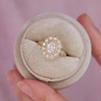 2 CT oval lab grown diamond vintage engagement ring with a starburst double halo in a beige velvet box.