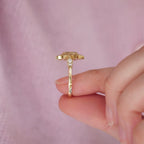 Side profile view of a 2 CT oval lab diamond ring showing shoulder accent diamonds and gold setting structure.