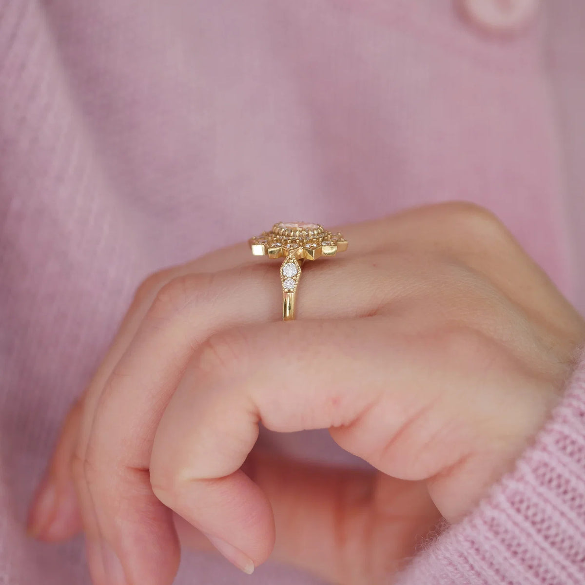 Side perspective of a 2 CT oval lab created diamond ring with milgrain shoulder accents worn on a hand.