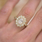 Close-up top view of a 2 CT oval lab diamond engagement ring with starburst double halo worn on finger.