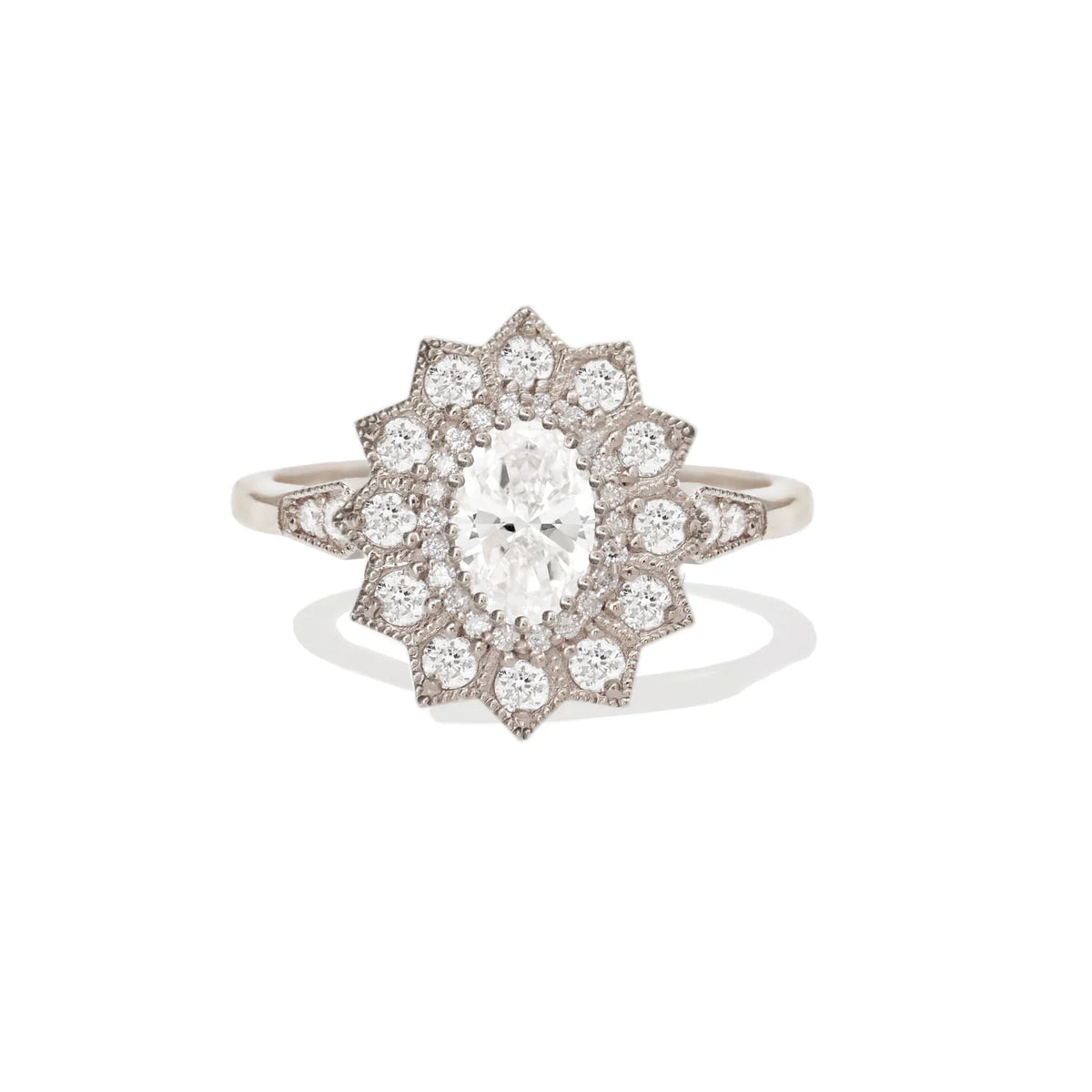 Studio view of a 2 CT oval lab grown diamond engagement ring with a vintage starburst halo setting in white gold.