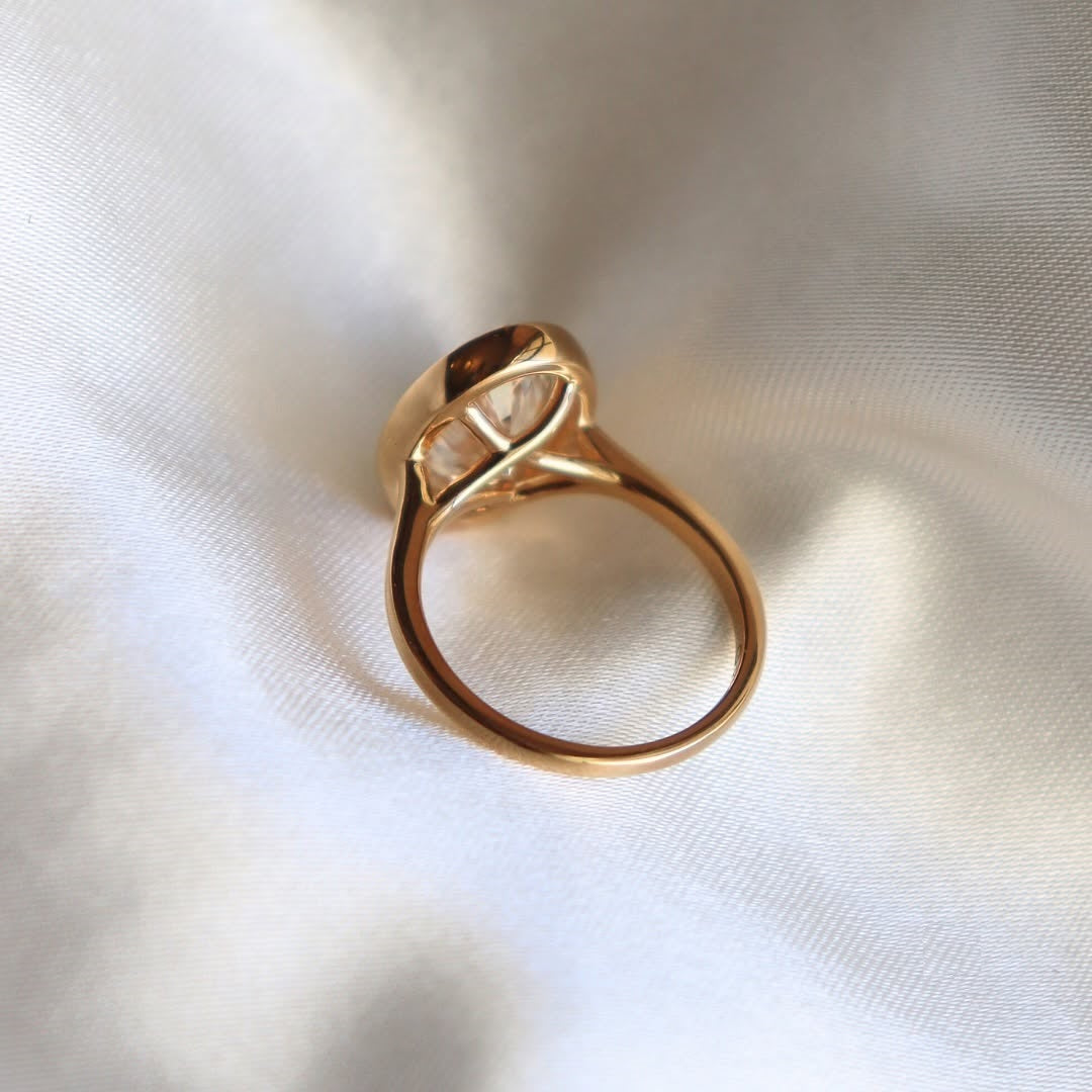 Under-gallery profile view of a yellow gold bezel set oval lab diamond solitaire ring 