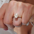 Top view of a 2 CT oval lab diamond ring with milgrain pavé band worn on finger.