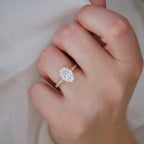 Overhead perspective of a 2 CT oval lab created diamond ring with white silk fabric background.