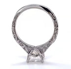 Bottom view of white gold engagement ring displaying the continuous carved scrollwork band and four-prong basket structure under the center diamond.