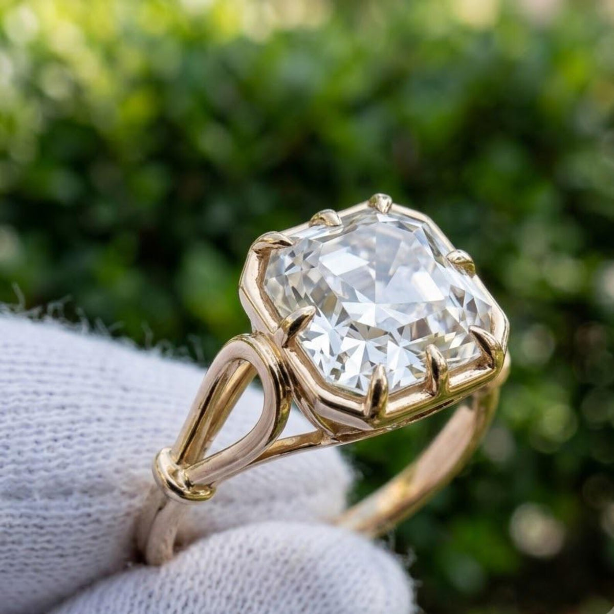 Side profile of a 3 CT Asscher cut lab grown diamond engagement ring in 14K yellow gold displaying the openwork basket and split shank.