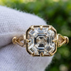 Direct top-down view of 3 CT Asscher cut lab grown diamond showing step facets, octagon shape, and 8-claw prong yellow gold setting.