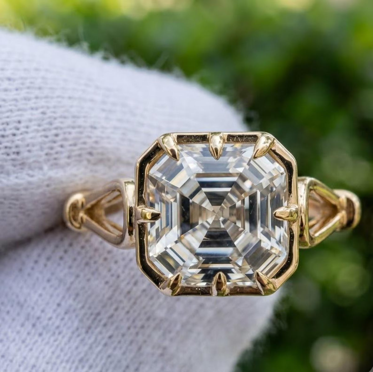 Direct top-down view of 3 CT Asscher cut lab grown diamond showing step facets, octagon shape, and 8-claw prong yellow gold setting.
