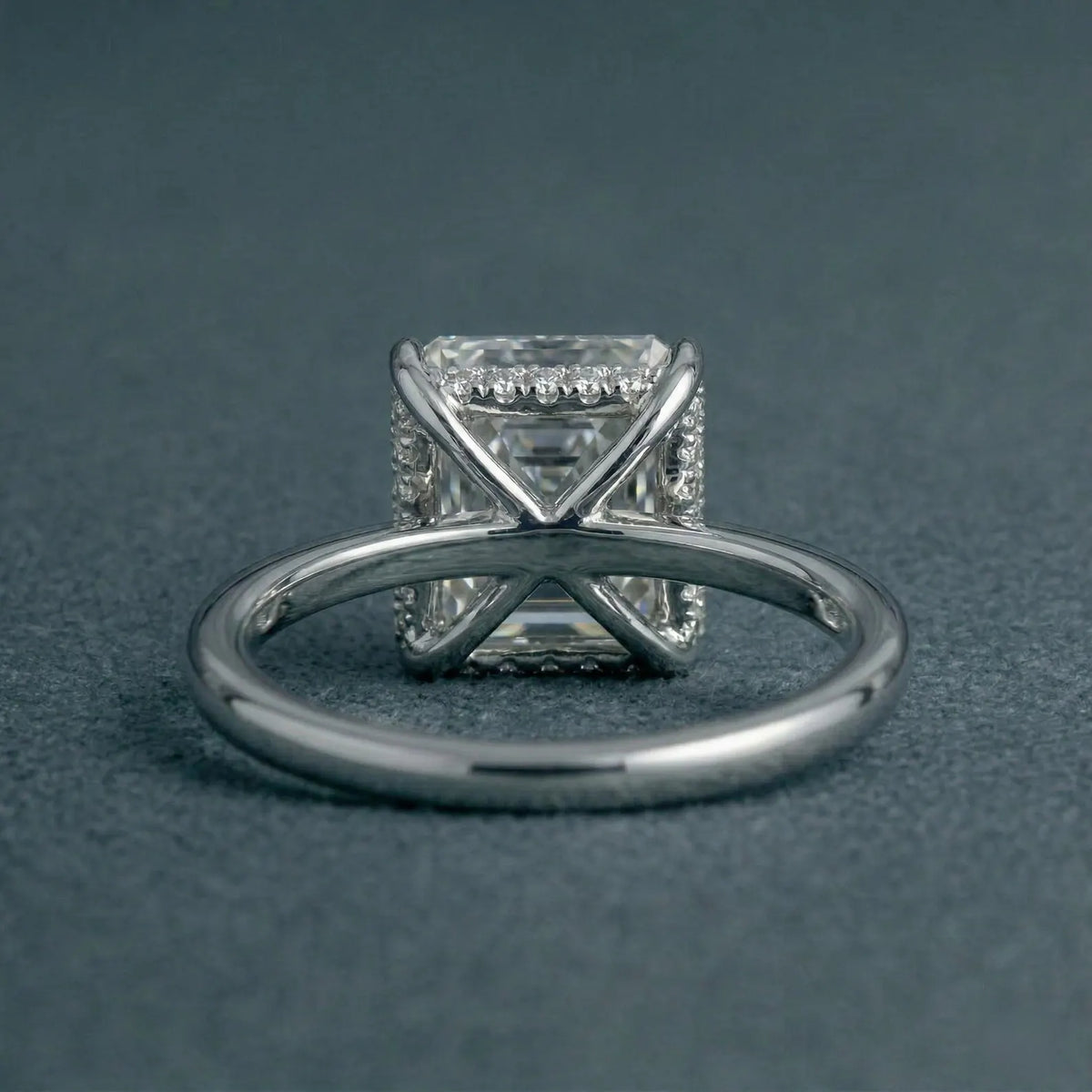 Underside view of a 3 carat Asscher cut lab diamond ring showing the structural X-shaped bridge gallery and hidden halo detailing.