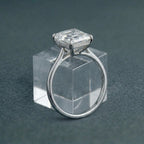 3 CT Asscher cut lab grown diamond solitaire engagement ring displayed on a clear glass block.