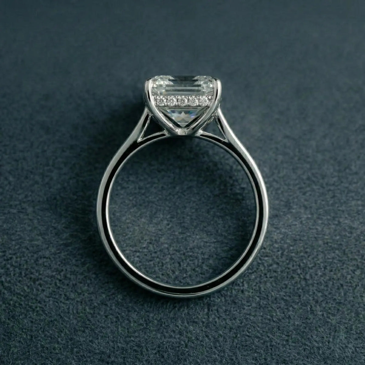 Direct side elevation of an Asscher cut lab diamond engagement ring showcasing cathedral shoulders and a sparkling hidden halo collar.