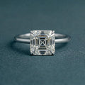 Direct top-down view highlighting the square step-cut facets and four-prong setting of a 3 carat Asscher cut lab grown diamond.