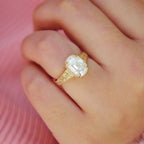 On-hand view of a 3 CT elongated cushion cut lab grown diamond engagement ring in yellow gold featuring vintage floral engraving.