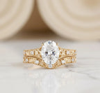 Vintage style 2 carat oval lab created diamond engagement ring and carved band stack in 14k yellow gold.