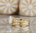 Side profile view of yellow gold vintage oval lab diamond engagement ring showing intricate floral scrollwork and accent side stones.