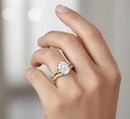 On hand model view of a 2 carat oval lab grown diamond vintage filigree engagement ring stack in yellow gold.