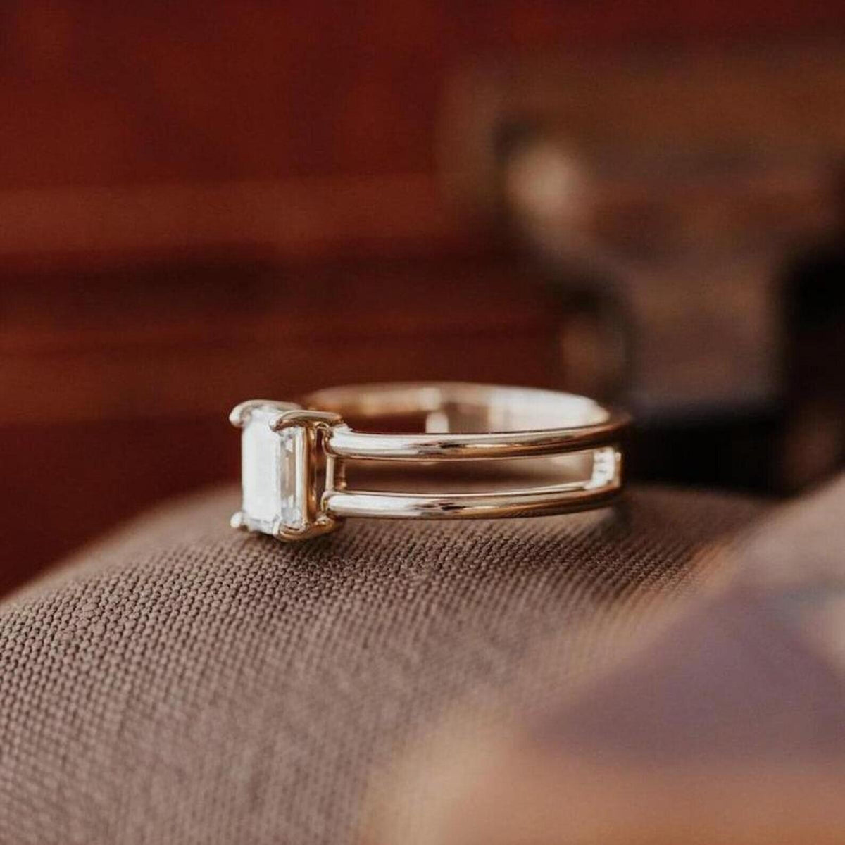 Side profile view of modern emerald cut lab grown diamond ring with open double-row band architecture.
