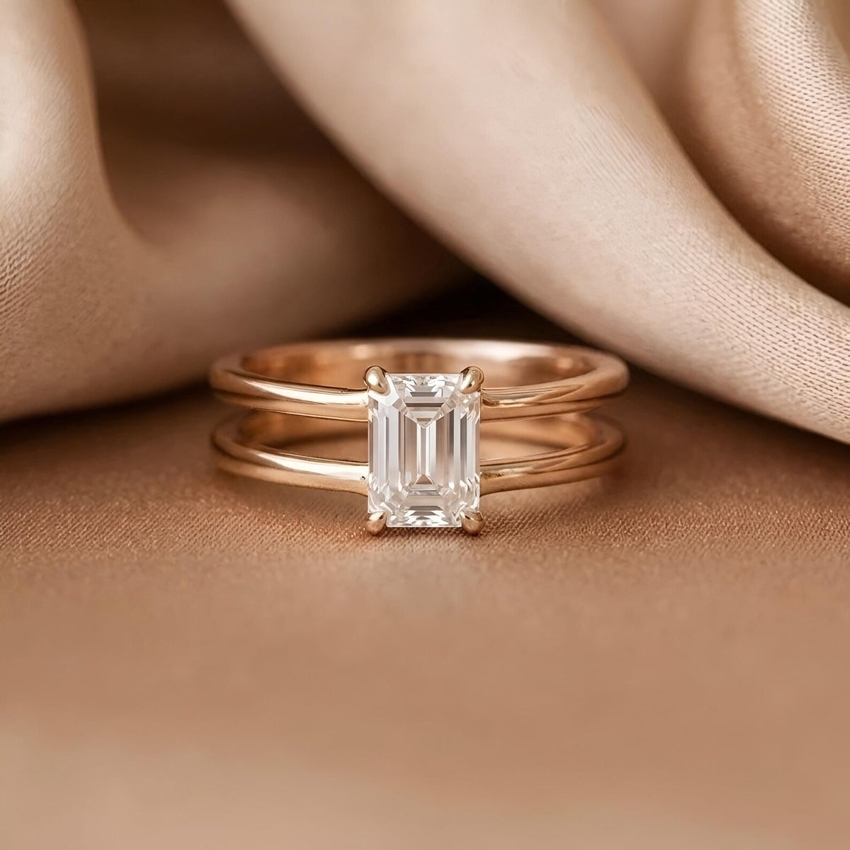 Close-up front view of 2 CT emerald cut lab grown diamond solitaire ring on champagne silk background.
