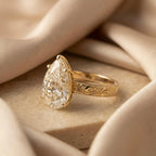 Perspective studio shot of 3 CT pear lab grown diamond solitaire engagement ring in 14K yellow gold.