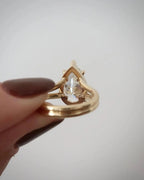 Side profile view of a 4 CT pear lab grown diamond ring with double band and open undergallery setting in yellow gold.