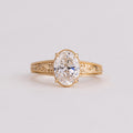 Frontal close-up view of a 2 CT oval lab created diamond solitaire ring with milgrain trim and engraved band.