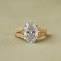 Front top-down view highlighting the brilliant oval lab grown diamond and intricate gold filigree band details.