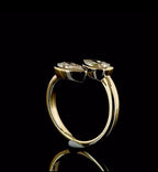 Side profile view of a yellow gold open cuff bypass ring with two raised bezel-set pear lab diamonds.