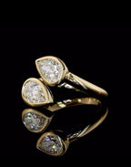 Angled perspective of a yellow gold Toi et Moi two-stone pear lab diamond bezel ring