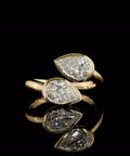 Front view showcasing twin pear cut lab diamonds in full bezel settings on a polished yellow gold bypass band
