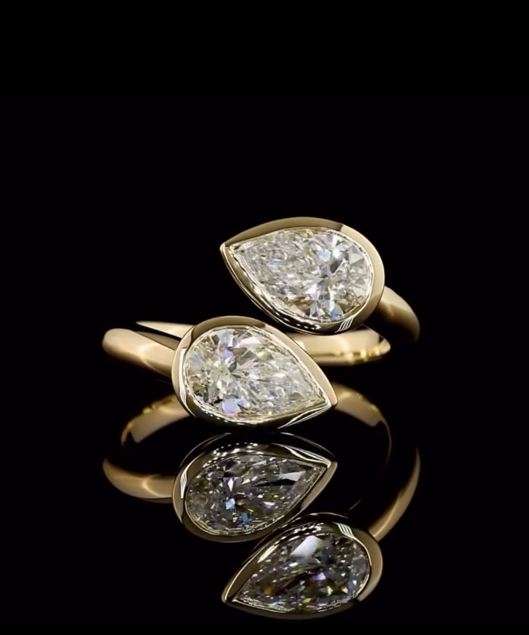 Front view showcasing twin pear cut lab diamonds in full bezel settings on a polished yellow gold bypass band