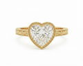 Top view of a 3 carat heart cut lab grown diamond engagement ring in yellow gold with milgrain bezel setting.