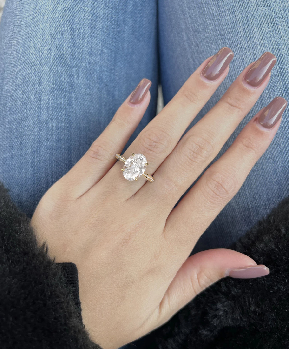 Hand model wearing the 5 ct oval lab-grown diamond ring, demonstrating scale and finger coverage.