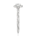 A silver diamond engagement ring with a round-cut center stone and a halo of smaller diamonds, featuring a twisted shank paved with diamonds, shown on a white background.