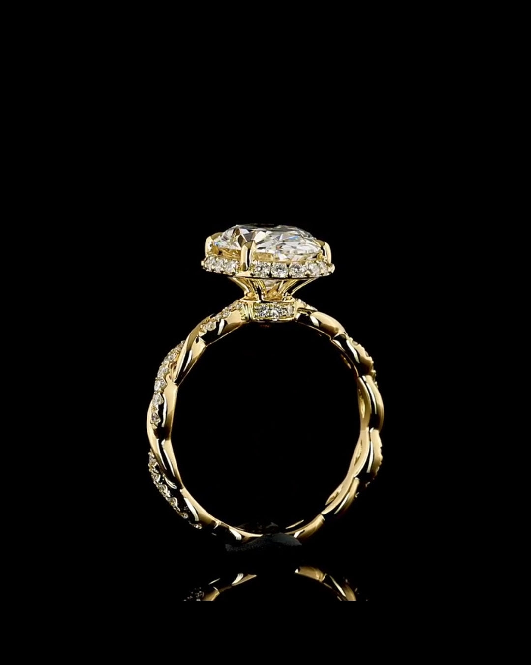 Profile view of a 4 carat oval lab grown diamond engagement ring with a hidden halo and twisted pavé band in yellow gold.