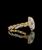 A yellow gold ring with a large oval clear gemstone surrounded by small pavé diamonds and a twisted diamond-accented band