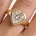 3-carat-heart-cut-lab-grown-diamond-bezel-set-engagement-ring-worn-on-finger