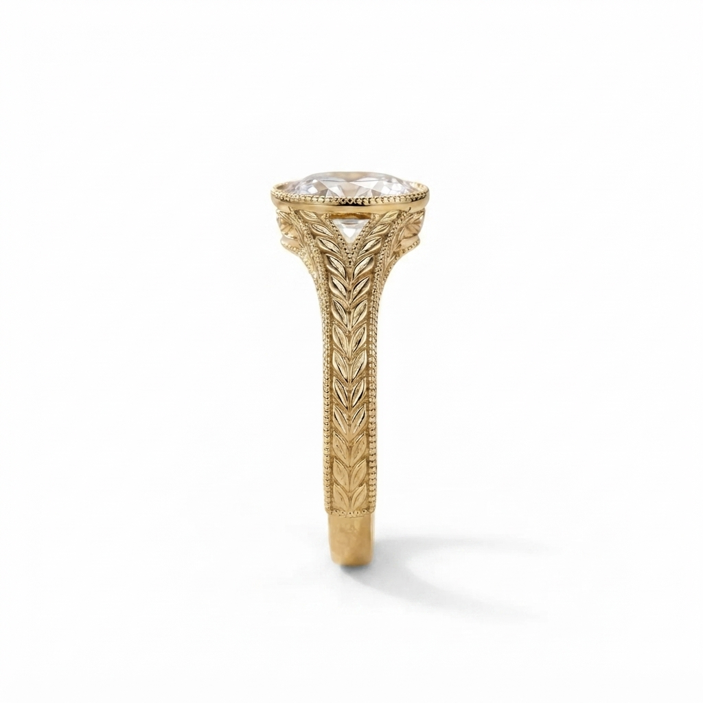 Detailed top-down view of the intricate wheat leaf engraving on the yellow gold band of an oval diamond ring.