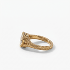 Macro perspective of the antique-inspired leaf-carved gold gallery on a 2 CT oval diamond ring.