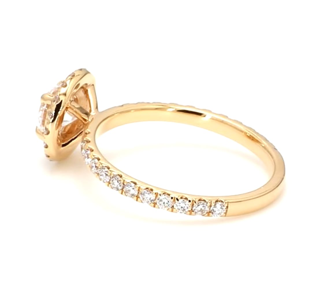 Side profile view of a 2 Ct round cut lab-grown diamond halo engagement ring showing the 18K yellow gold band with pavé accent diamonds.